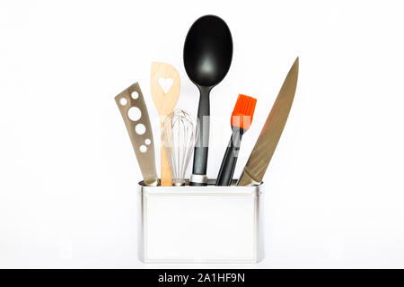 Assortment of kitchenware and cooking tools in a square silver colored metal box with copy space on white background Stock Photo