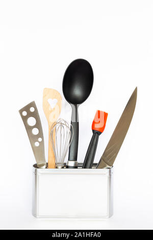 Assortment of kitchenware and cooking tools in a square silver colored metal box with copy space on white background Stock Photo