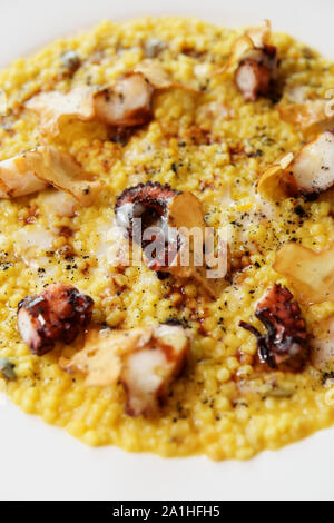 Fregola pasta cooked in risotto style with grilled octopus, Sardinian dish Stock Photo