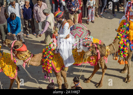 Jaisalmer, India - February 17, 2019: Ceremonial procession Camels and riders in Desert Festival in Jaisalmer. Rajasthan Stock Photo