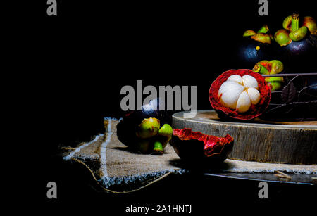Mangosteens or queen of fruits. Mangosteens black many whole fruits on Black background. Stock Photo