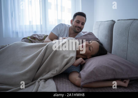 Young couple is lying in bed and waking up in the morning.