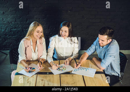 Young team of coworkers making great meeting discussion in modern coworking office. Teamwork process. Horizontal,blurred background. Stock Photo