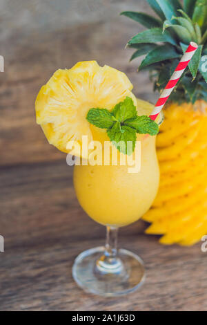 Pineapple and pineapple smoothies on an old wooden background. Stock Photo