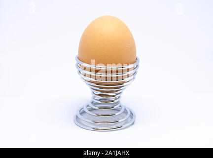 Boiled egg in an egg cup on a white background. Stock Photo