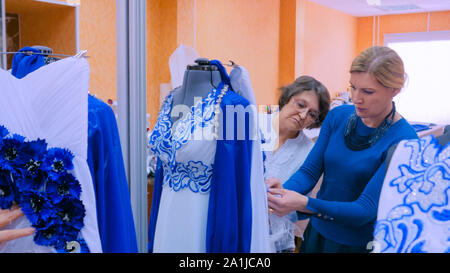 Two fashion designers working with new model tailoring dress on mannequin Stock Photo
