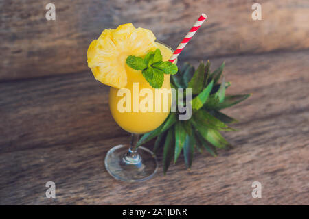 Pineapple and pineapple smoothies on an old wooden background. Stock Photo