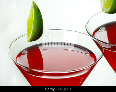 Bright red Bacardi alcoholic cocktail of white rum, lime juice and grenadine, in cocktail glasses decorated with lime slices, on a light background Stock Photo