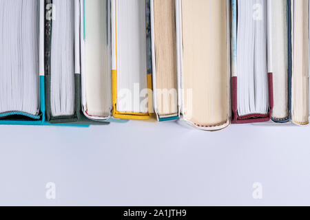 A row of books on a white surface viewed from above Stock Photo