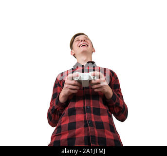 Cheerful teen boy playing video games isolated over white background. Excited adolescent stand all ears holding a joystick console looking attentive t Stock Photo