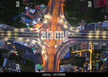 Aerial view of highway junctions Top view of Urban city, Bangkok at night, Thailand. Light trails across road junction, traffic abstract and transport