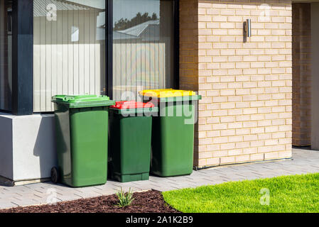 Australian waste wheelie bins with colourful lids for recycling, green and general waste provided by local government Stock Photo