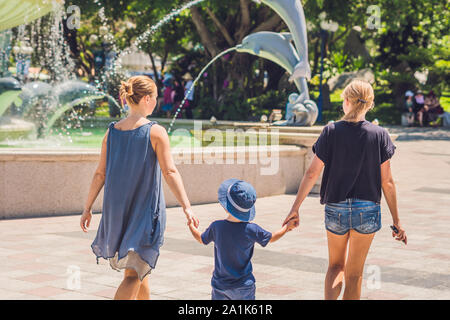 Tourists of a woman and a boy are walking in the amusement park Stock Photo