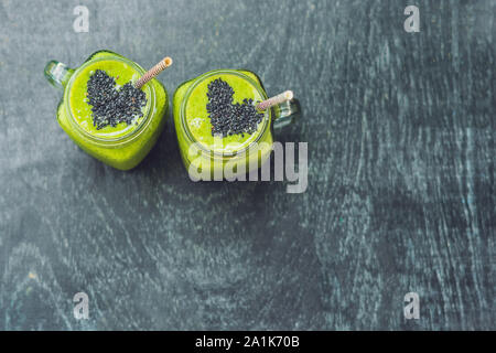 Fresh green smoothie with banana and spinach with heart of sesame seeds. Love for a healthy raw food concept Stock Photo