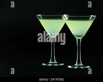 A classic daiquiri alcoholic cocktail of light green color from white rum, simple syrup and lime juice, in two conical cocktail glasses Stock Photo