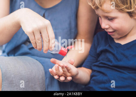 Mother and son using wash hand sanitizer gel pump dispenser Stock Photo