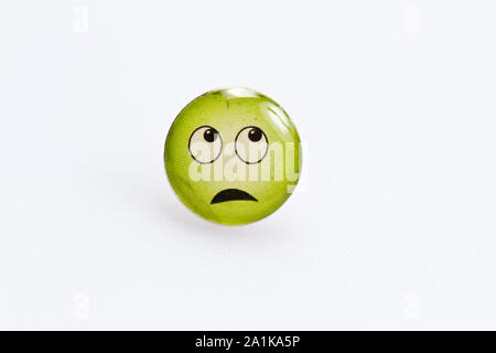 smiley character on metal thumbtack on white surface Stock Photo