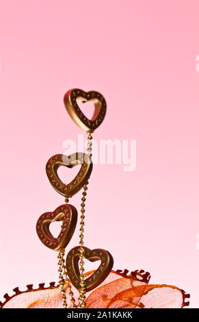 four plastic hearts at left frame with pink background in landscape  orientation for valentine Stock Photo - Alamy