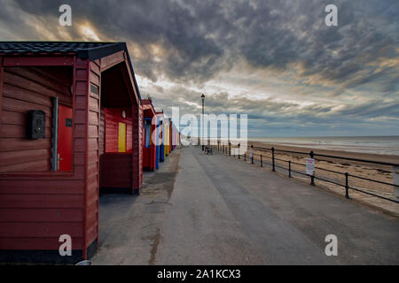 Multi coloured beach huts on coast Stock Photo