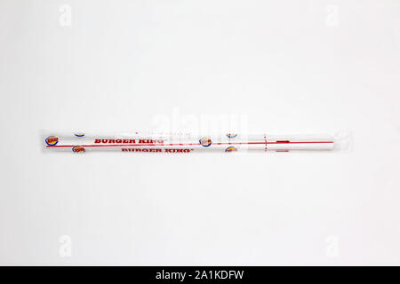 Plastic straw wrapped in plastic cellophane from Burger King chain of hamburger fast food restaurant, isolated on white background, close-up Stock Photo