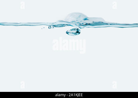 Studio shot of a small water wave against white background. Stock Photo