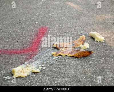 Banana and peel on sidewalk that somone evidently slipped on. Stock Photo