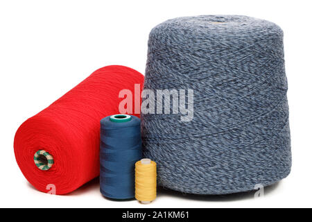 Cones and spools of synthetic or cotton threads on white background. Spool of yarn using for weaving in textile manufacturing Stock Photo