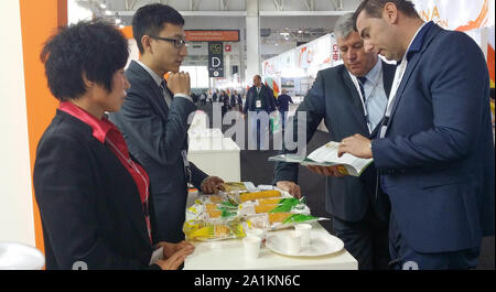 (190927) -- CHANGCHUN, Sept. 27, 2019 (Xinhua) -- File photo taken on Oct. 21, 2014 shows Sui Shuxia (1st L) talks with clients at a food fair in Paris, France. Sui, 52, started her corn business seven years ago. With support from local government, corn products of Sui's company promote well in oversea market. So far the annual corn production of 16 planting bases in northeast China reached 25,000 tonnes. The total output value is expected to exceed 150 million yuan (about 21.04 million U.S. dollars) this year. In the future, Sui plans to improve the deep processing of corns and expand offline Stock Photo