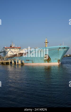 Products Tanker discharging at the Oil Terminal of lorient, France, with blue hull on sunny day. Verticale view. Stock Photo
