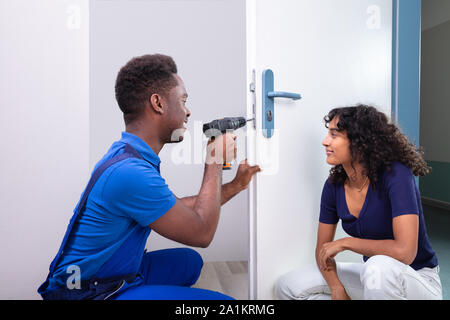 Technician Fixing The Door Lock At Clients Home Stock Photo