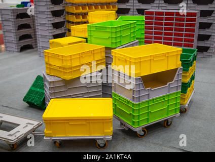 Stack of colorful empty plastic crate on trolley Stock Photo
