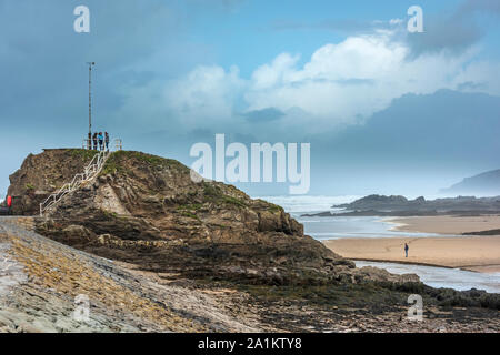 Bude, North Cornwall, England. Friday 27th September 2019. UK Weather. After a night of torrential rain and gale force winds, the stormy weather continues as a man enjoys a walk on windswept Summerleaze Beach and three friends climb the steps on the breakwater in  Bude North Cornwall. Terry Mathews/Alamy Live News. Stock Photo