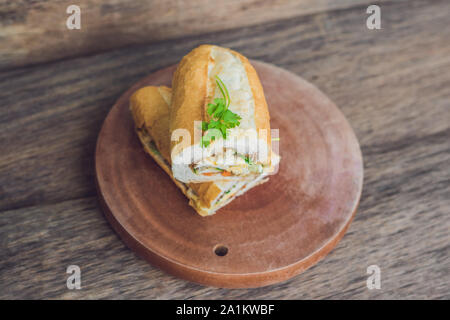A delicious Vietnamese Bahn Mi sandwich on a wooden background Stock Photo