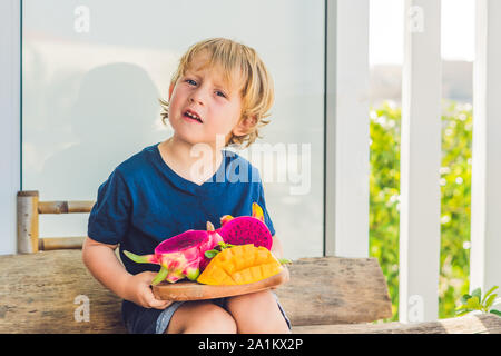 Diced dragon fruit and mango in the hands of the boy Stock Photo