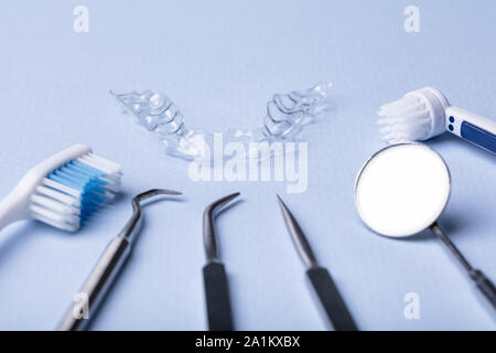Dental Instruments And Clear Aligner On Color Background Stock Photo