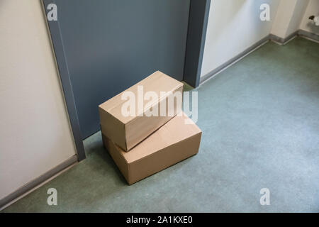 Close-up Of Cardboard Parcel Boxes Delivered Outside Front Door Stock Photo