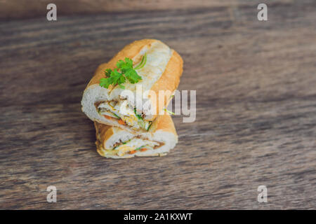 A delicious Vietnamese Bahn Mi sandwich on a wooden background Stock Photo