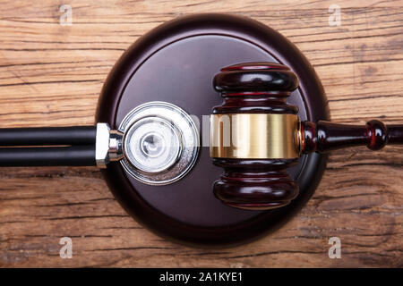 High Angle View Of Gavel With Stethoscope Arranged On Wooden Table Stock Photo