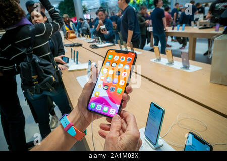 A customer in the newly opened Apple store on Fifth Avenue in New York inspects a new iPhone 11 Pro Max on Friday, September 20, 2019, the first day they went on sale.  The new phones, the iPhone 11, iPhone 11 Pro and the iPhone 11 Max , anxiously awaited by drooling iPhone aficionados, sell between $699 and up to $1449 depending on the model and storage choices.  (© Richard B. Levine) Stock Photo