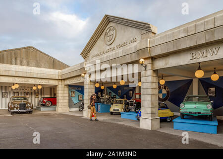 Simulated motor showrooms under the title of March Motor Works 1948-1966. Photographer taking a picture at the 2019 Goodwood Revival, Sussex, UK Stock Photo