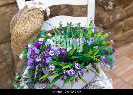 white wooden chair with a pot full of flowers Stock Photo