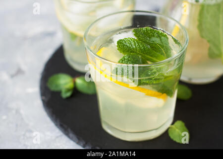 Glass of iced tea with lemon, ginger and mint on slate plate Stock Photo