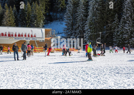 Bansko, Bulgaria - December, 12, 2015: Bansko Banderitza ski lift at Banderishka polyana, Bulgaria, pistes and mountain with pine trees, people Stock Photo