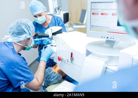 Surgical team performing laser eye surgery. Stock Photo