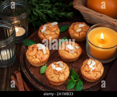 Gluten free pumpkin and carrot muffins decorated with almonds on dark wooden cutting board. Thanksgiving Day dessert Stock Photo