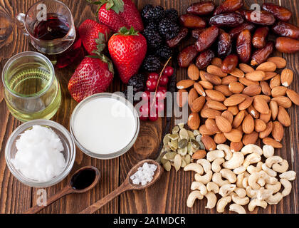 Berries, nuts, coconut milk and butter, maple sirup. Ingredients for raw vegan cheesecake with caramel sirup and fresh berries preparation Stock Photo