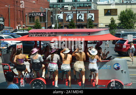 Young men and women peddle a Party Bike along a street in Nashville, Tennessee's entertainment district Stock Photo