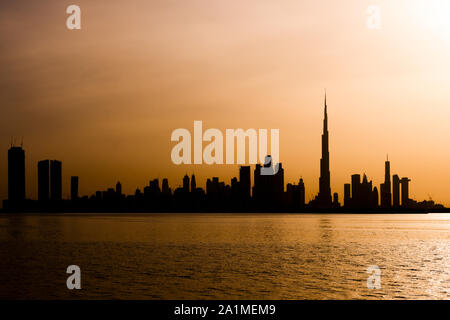 Stunning view of the silhouette of the Dubai skyline during a beautiful and dramatic sunset. Dubai is the largest and most populous city in the UAE. Stock Photo