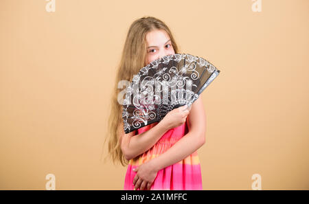 Cooling effect. Folding fans. Acting school. Dances with fan. Girl fanning herself with fan. Air circulation. Art and culture. Handheld fan create airflow. Airflow from handfans increases evaporation. Stock Photo