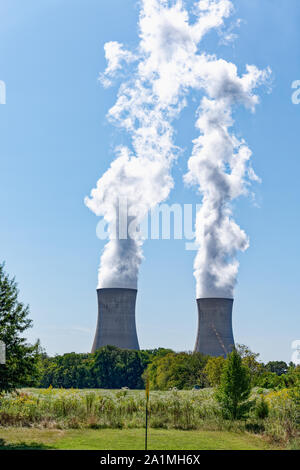 Steam pouring out of the natural draft cooling towers of the Limerick Generating Station nuclear power plant in Pottstown, PA with blue sky and lush g Stock Photo